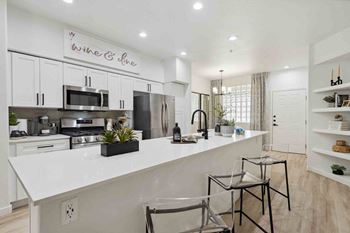 a kitchen with a large counter and two stools
